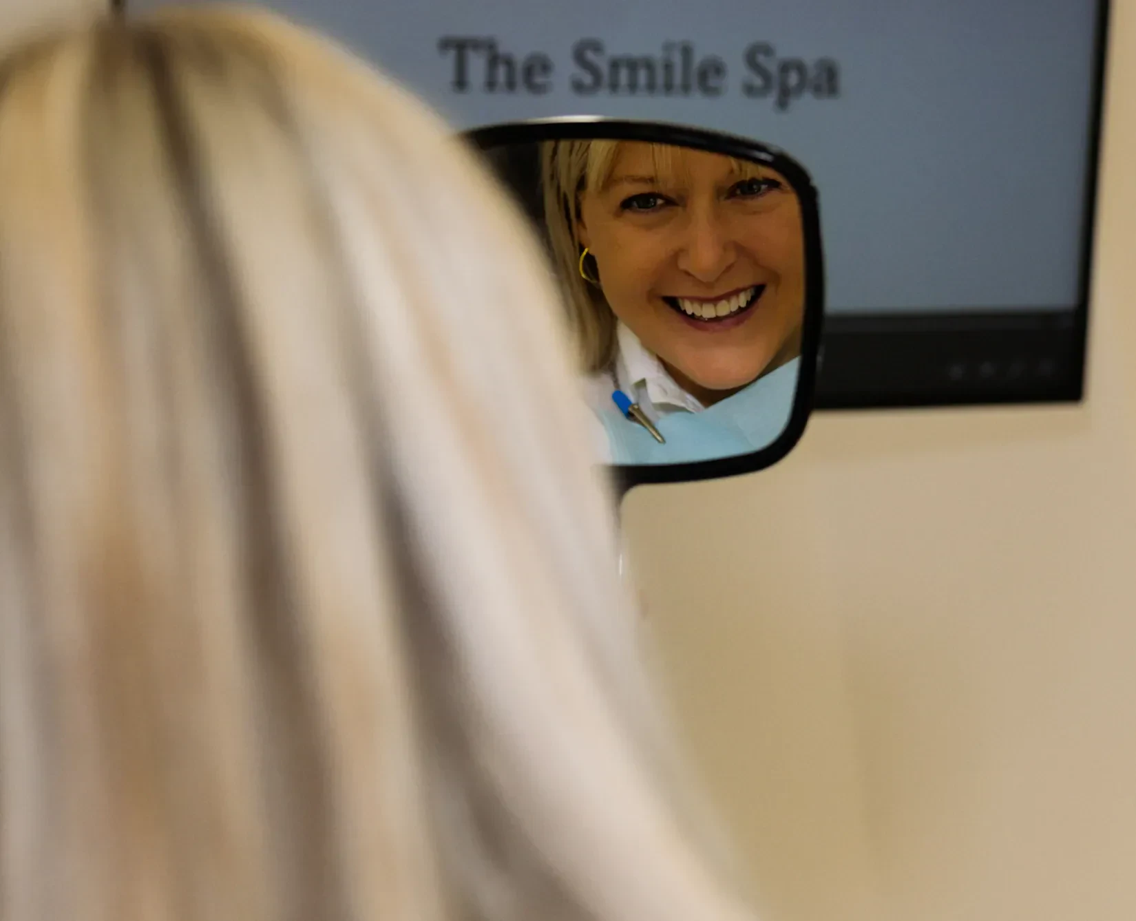 A patient admiring her new smile in the mirror
